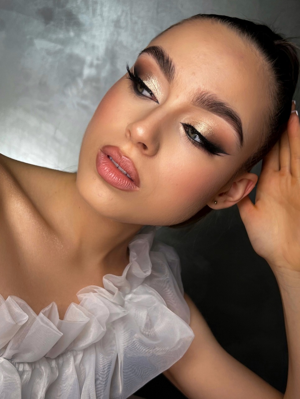 Kobieta w stylowym makijażu okolicznościowym z pomalowanymi brwiami